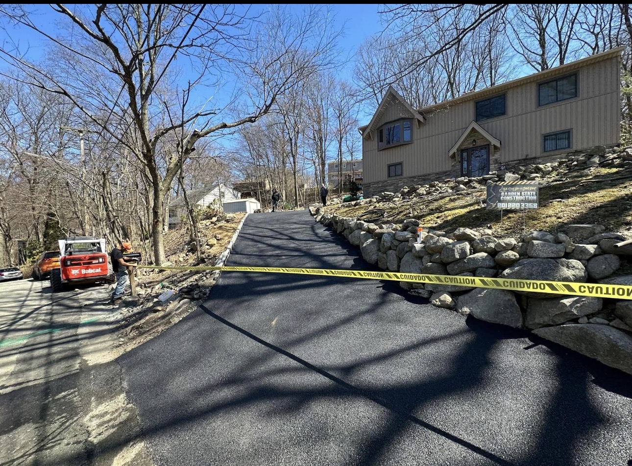 New asphalt driveway winding up a wooded hillside in NJ