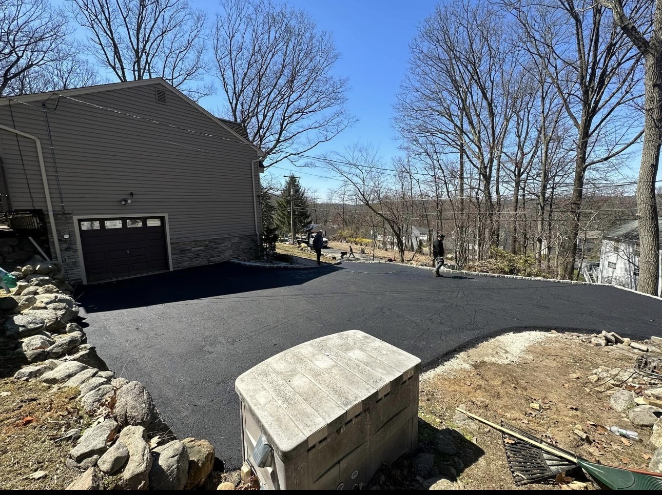 Completed asphalt driveway leading to a hillside garage in NJ
